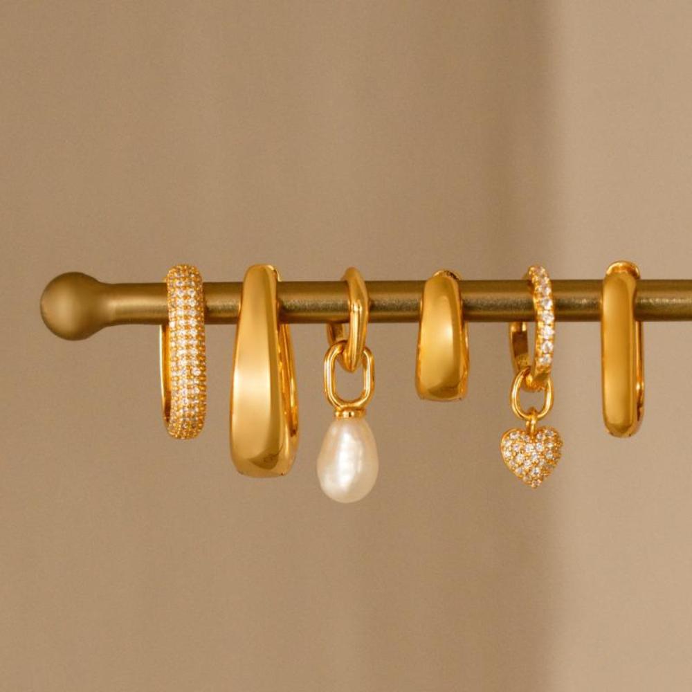 Verzameling gouden statement oorbellen van Bedels & Bedels, voorzien van 18K gold plating en zirkonia-steentjes voor een elegante en verfijnde uitstraling.