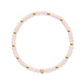 Fijne gold filled armband met 3mm rozenkwarts kraaltjes en gouden accenten op witte achtergrond