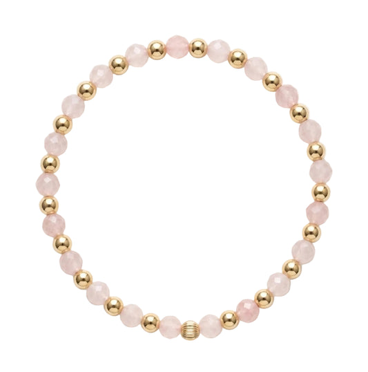 Gold filled armband van Bedels & Bedels met roze rozenkwarts kralen en gouden balletjes op witte achtergrond