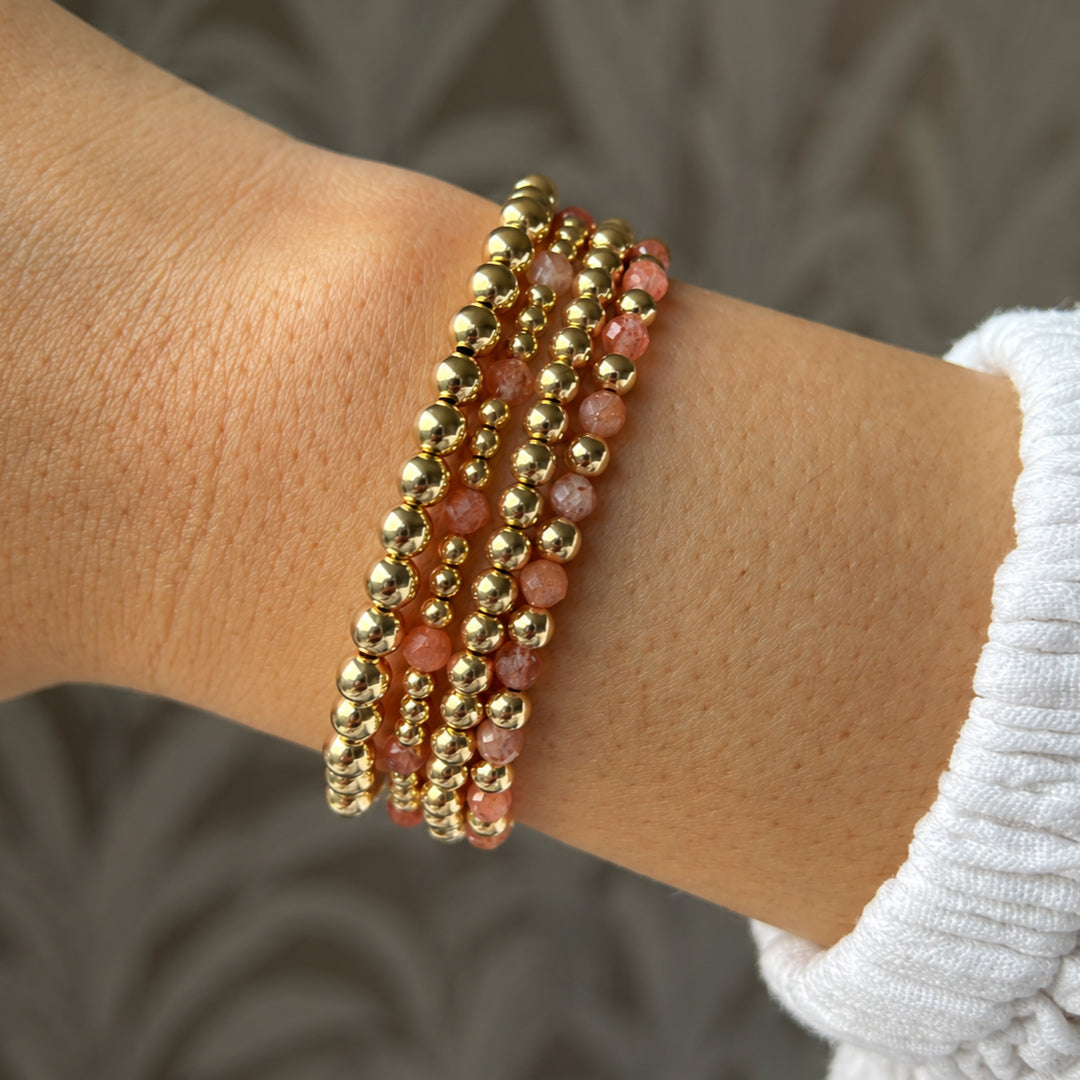 Gouden armbanden met zonnesteen en gouden kralen van gold filled 14K naast elkaar, van Bedels & Bedels.