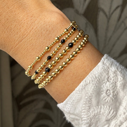 Gouden kralenarmbanden van gold filled 14K met zwarte spinel edelstenen, van Bedels & Bedels.