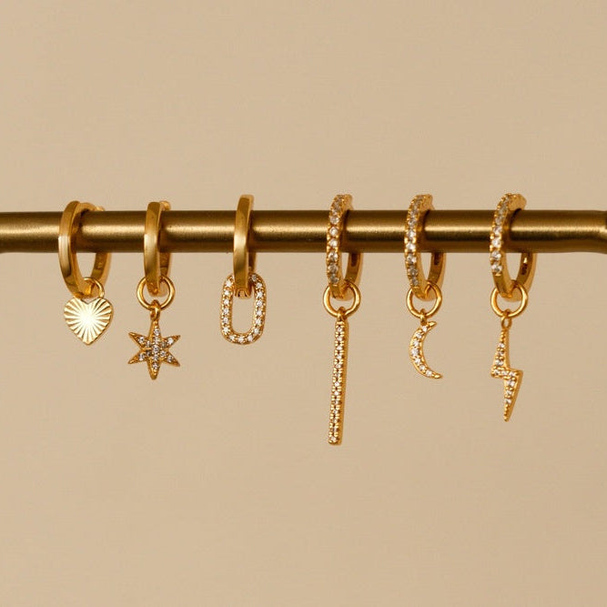 Oorbellen met gouden bedels en zirkonia.