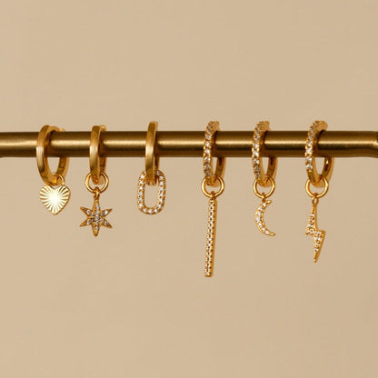 Oorbellen met gouden bedels en zirkonia.