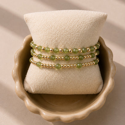 Drie gouden armbanden met groene peridoot edelstenen van gold filled 14K, van Bedels & Bedels.