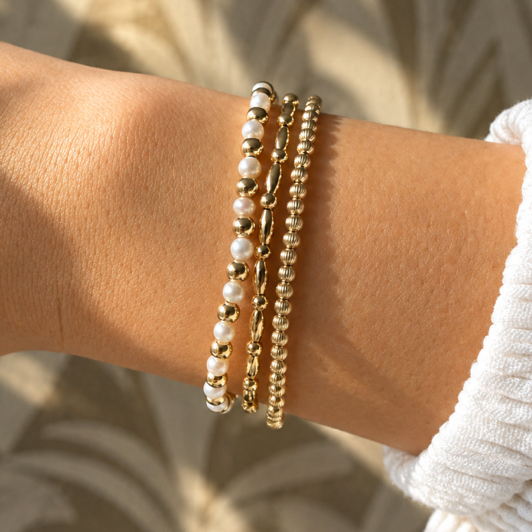 Verschillende gouden kralenarmbanden en parelarmbanden van gold filled 14K, van Bedels & Bedels.