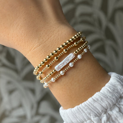 Gouden kralenarmbanden en parelarmbanden van gold filled 14K naast elkaar, van Bedels & Bedels.